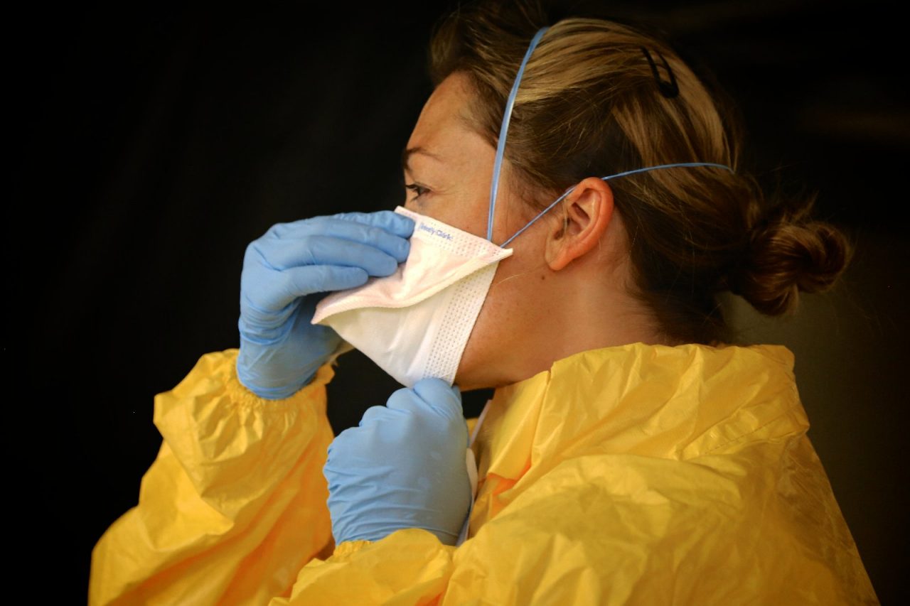Ebola worker donning protective wear.